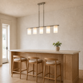 In scale | brushed nickel pendant over an island beside a full-height doorway