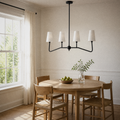 Dining angle | second view of the black four-arm pendant and white shades above a round oak table