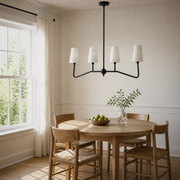 Dining angle | second view of the black four-arm pendant and white shades above a round oak table