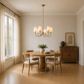 Scale | small six-light warm brass chandelier in a full-height dining room with window reveal
