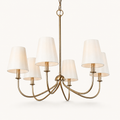 Front | six-light warm brass chandelier with six ivory linen shades, chain, and canopy on white