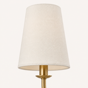 Fabric detail | close view of ivory linen shade weave, stitched edge, warm brass socket, and curved arm