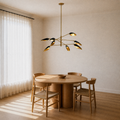 Dining room angle | eight-light chandelier with black cone shades and gold interiors above a round oak table