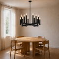 Warm dining room three-quarter | dark aged-zinc 12-light chandelier above a round oak table