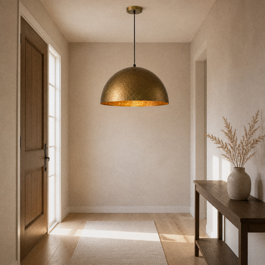 Entryway | hammered gold dome pendant hanging from the ceiling above a console