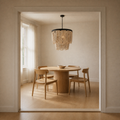 Scale | cream wood-bead chandelier hanging inside a full doorway opening over a dining table