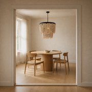 Scale | cream wood-bead chandelier hanging inside a full doorway opening over a dining table