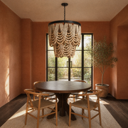 In a room | terracotta dining room with a cream wood-bead chandelier above a dark wood table