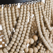 Texture | close-up of whitewashed wood beads with visible grain, string loops, and black metal rim