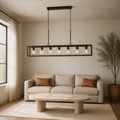 Living room | the chandelier hanging above a beige sofa, stone coffee table, and a potted plant in the corner