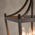 Hardware | Close macro of the burnished bronze cage rail, curved arm join, and ball finial