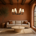 Terracotta living room | matte black six-light chandelier above a travertine coffee table