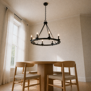 Low-angle dining room view | 8-light wagon-wheel chandelier over the round oak table