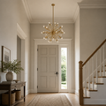 Scale | warm brass 24-light sphere chandelier shown at scale in an entry hall with a full-height door