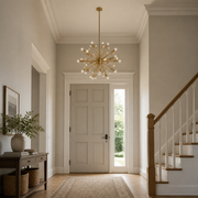 Scale | warm brass 24-light sphere chandelier shown at scale in an entry hall with a full-height door