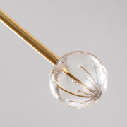Texture | macro view of the brushed brass arm and clear K9 crystal sphere