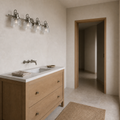 Scale | antique-nickel four-light vanity above a white-oak vanity with a full-height doorway for scale