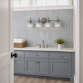 In a room | blue-gray tile bathroom with antique-nickel 4-light vanity above a painted vanity