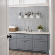 In a room | blue-gray tile bathroom with antique-nickel 4-light vanity above a painted vanity