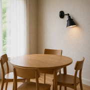 Dining room | second angle of the matte black cone wall sconce above the oak dining table