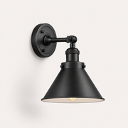Studio three-quarter | matte black cone wall sconce showing the arm, swivel joint, and shade depth
