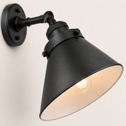 Close detail | matte black cone shade surface, rolled rim, knurled ring, and warm bulb