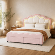 Angle | Three-quarter view showing the flower-shaped headboard, glowing outline, padded rails, and two drawers