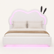 Front | Straight-on studio view of the white bed with its cloud-shaped back, illuminated outline, and rounded feet.