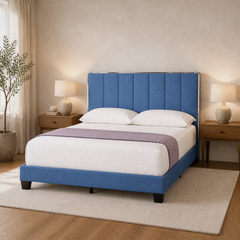 Room 1 angle | Three-quarter bedroom view showing the upholstered rails, tall headboard, dark legs, bedding, and wood floor