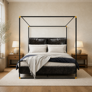 In a room | Front view of the black canopy bed with white bedding, wood nightstands, and a light rug