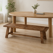 In a room | the same bench along a bright flax dining room's round table, soft midday light from the left