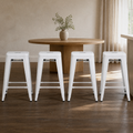 In a room | all four matching stools at a plaster dining room's island edge, low golden afternoon light from the right