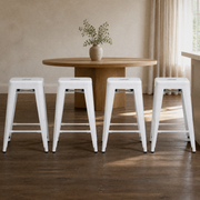 In a room | all four matching stools at a plaster dining room's island edge, low golden afternoon light from the right