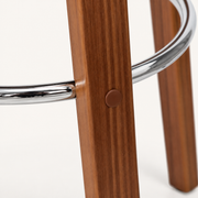 Detail | the polished chrome footrest ring where it meets the splayed wood legs