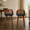 In a room | both matching stools at a plaster dining room's island edge, low golden afternoon light from the right