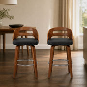 In a room | both matching stools at a plaster dining room's island edge, low golden afternoon light from the right