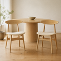 In a room | the pair at a pale-oak dining table, soft morning sidelight from the window