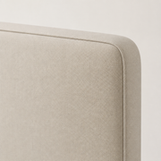 Piped edge | Close view of the piped beige headboard corner