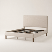 Studio three-quarter | Angled studio view of the beige upholstered bed with its low footboard and slat foundation