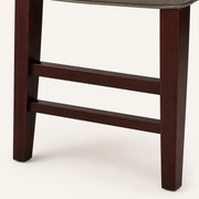 Detail | the built-in footrest bar and stretcher joinery in the dark wood frame