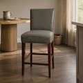 In a room | vintage gray faux-leather counter stool at a warm plaster dining room's island edge, low golden light from the right