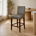 In a room | the stool at a pale-oak dining room's island edge, window at left, soft morning sidelight