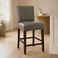In a room | the stool at a bright flax dining room's island edge, midday light from the left