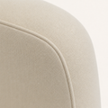 Closer | the plain beige woven fabric and the seam where the back panel wraps and joins