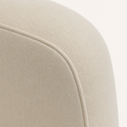 Closer | the plain beige woven fabric and the seam where the back panel wraps and joins