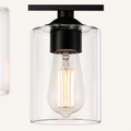Hardware | close view of one black socket, glass cylinder shade, and Edison-style bulb