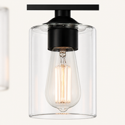 Hardware | close view of one black socket, glass cylinder shade, and Edison-style bulb
