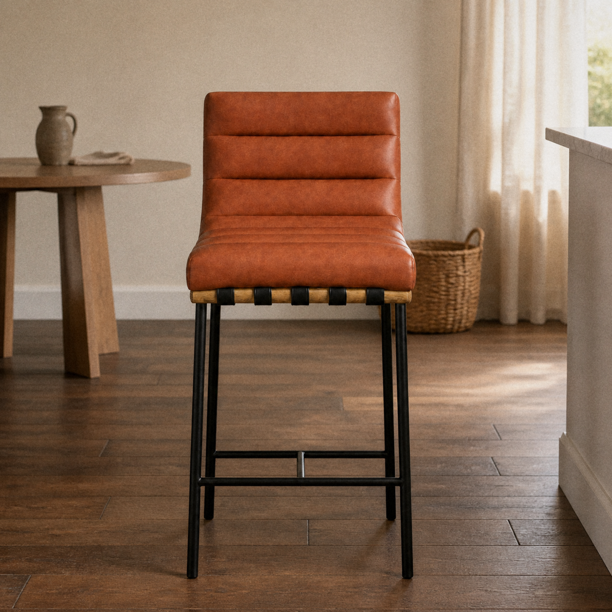 In a room | cognac channel-tufted counter stool at a warm plaster dining room's island edge, low golden late-afternoon light from the right