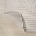 Close up | the carved high-low pile and finished edge, folded to show the backing