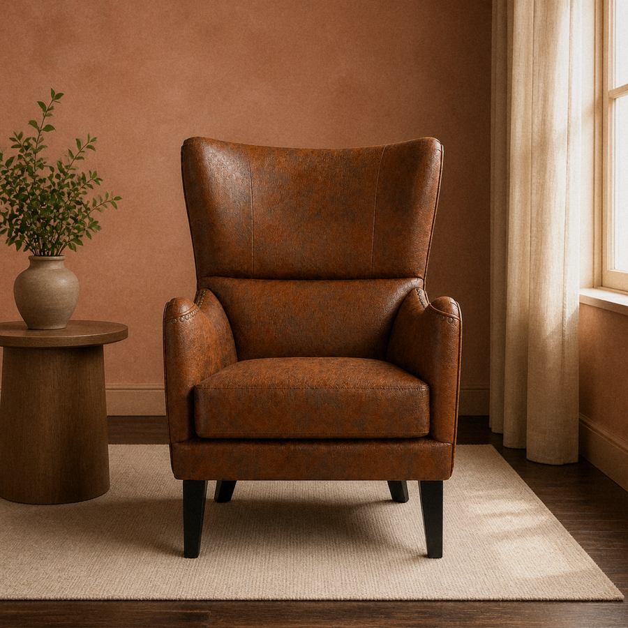 In a clay room | distressed brown embossed faux-leather wingback chair on a plain oatmeal rug, dark walnut floor, round side table and window